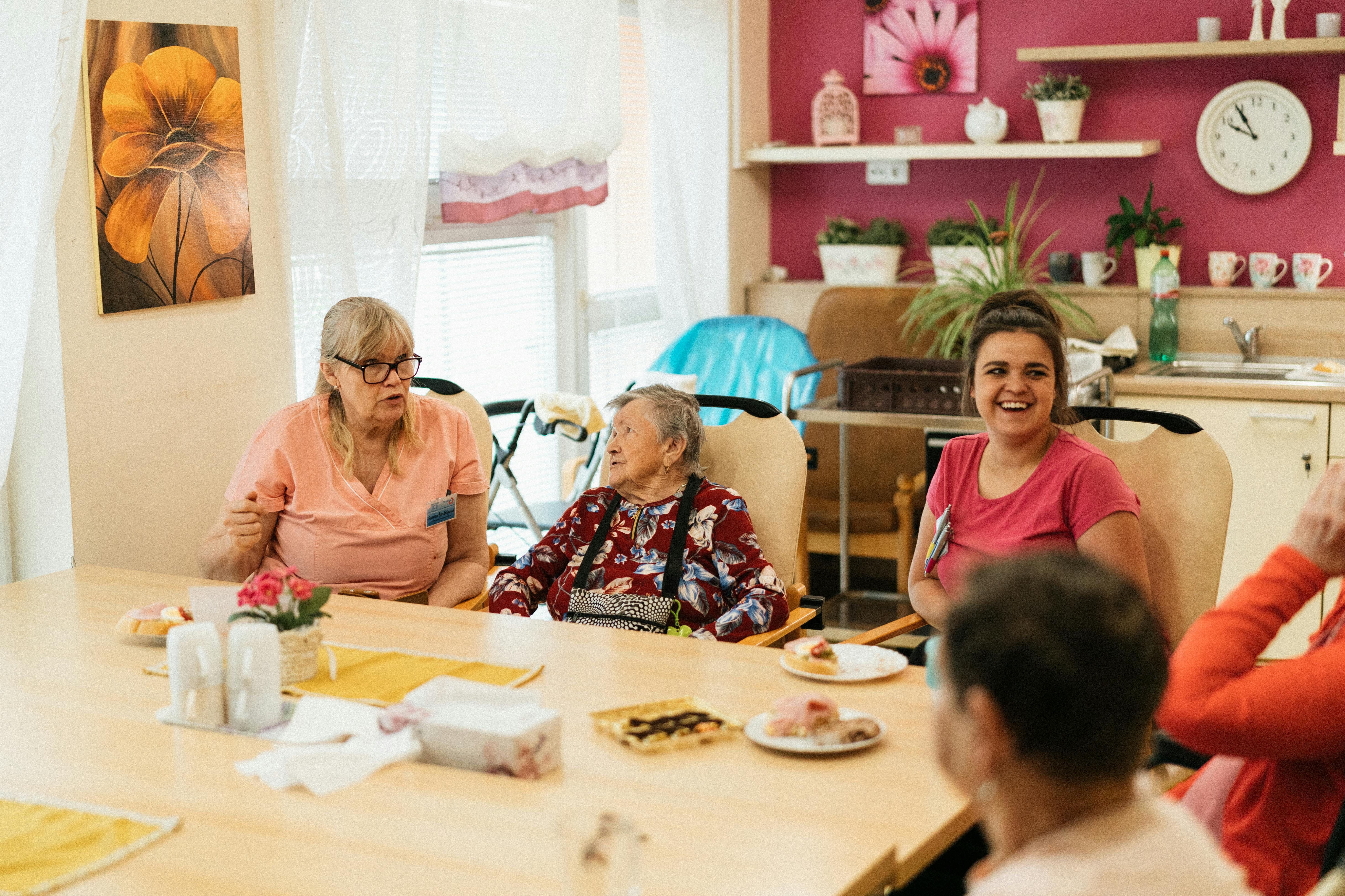Caregivers having a warm conversation with a resident in a comfortable living space